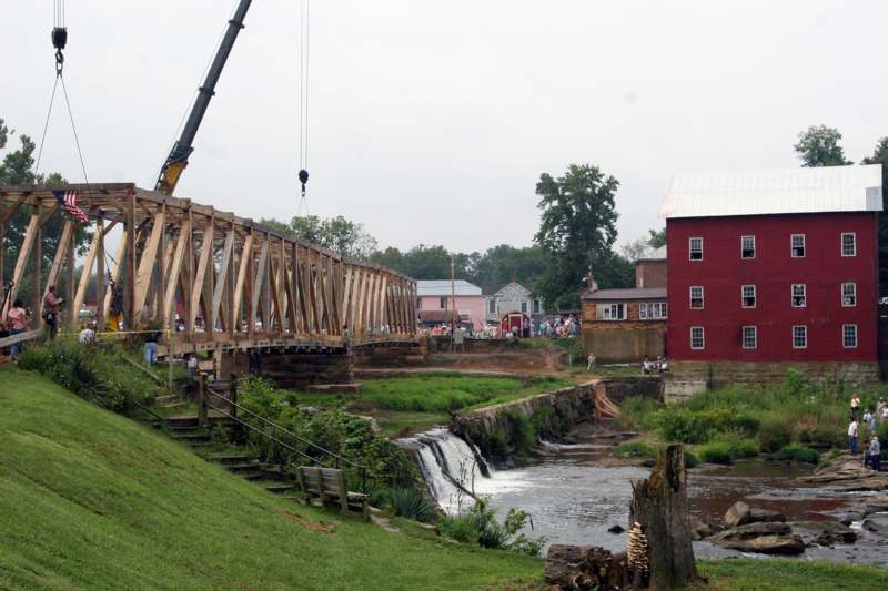 a crane lifting a bridge over a river
