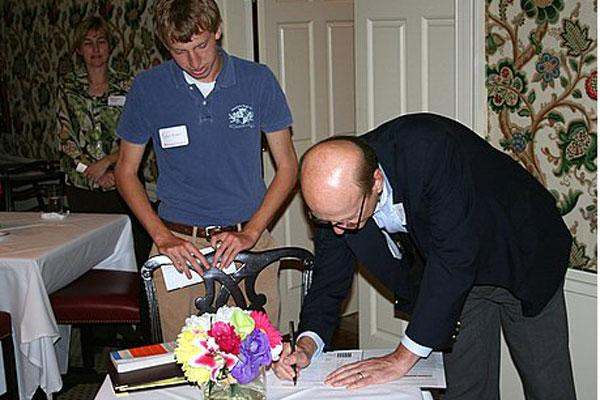 a man looking at a man holding a pen