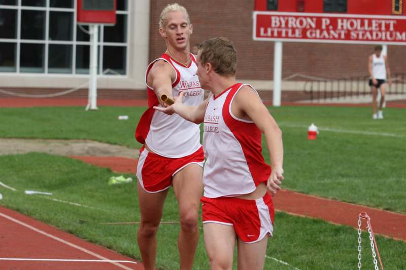 a group of men in red and white uniforms on a track