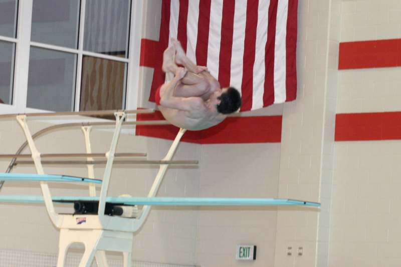 a man jumping on a parallel bars