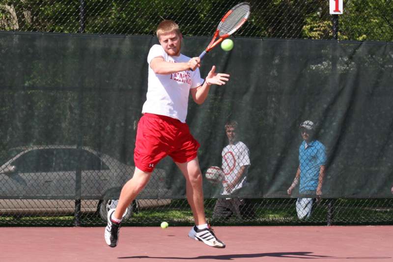 a man hitting a tennis ball with a racket