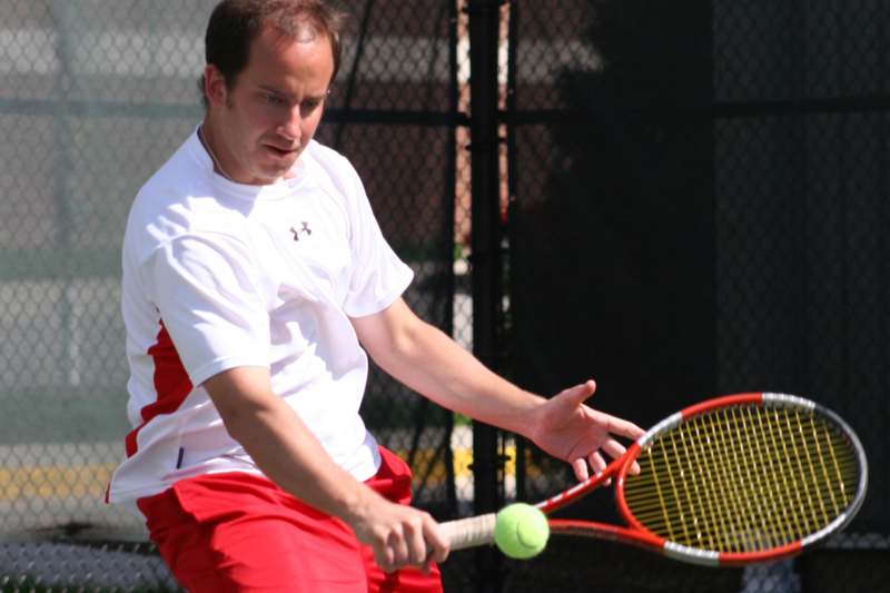a man hitting a tennis ball with a racket