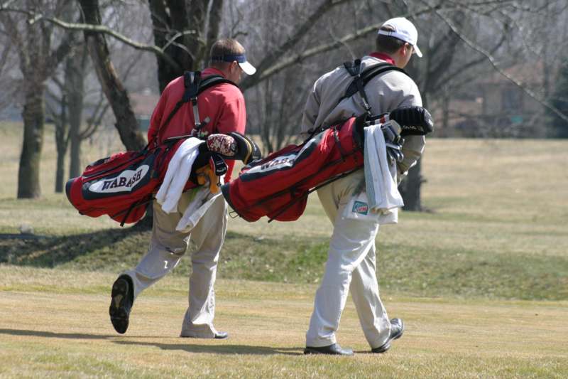 a group of men carrying golf clubs