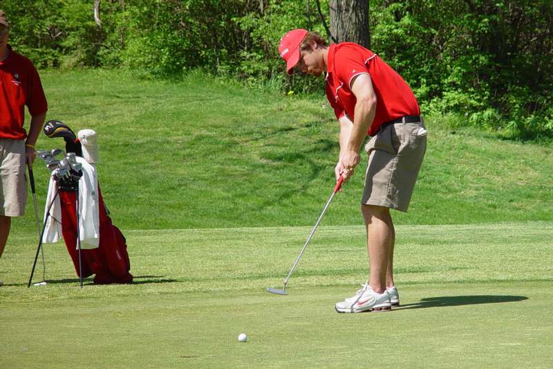 a man putting a golf ball on a golf course