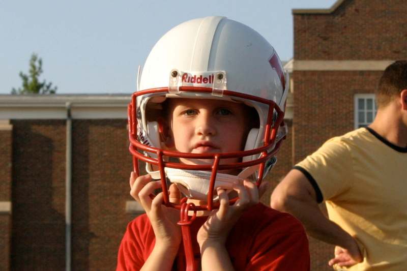 a young boy wearing a football helmet