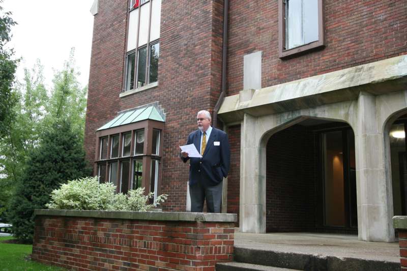 a man standing outside of a building holding a paper