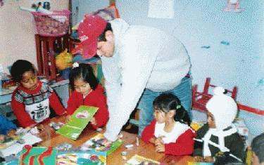 a man helping children with a book