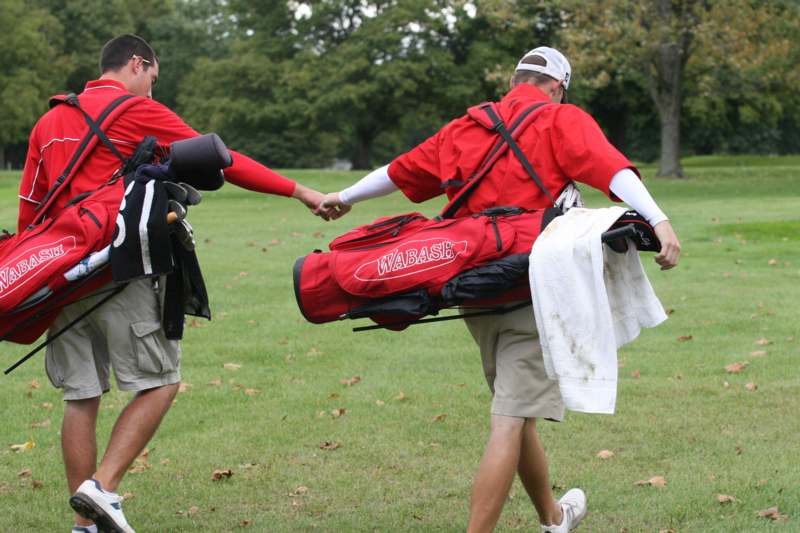 a group of men holding onto golf clubs