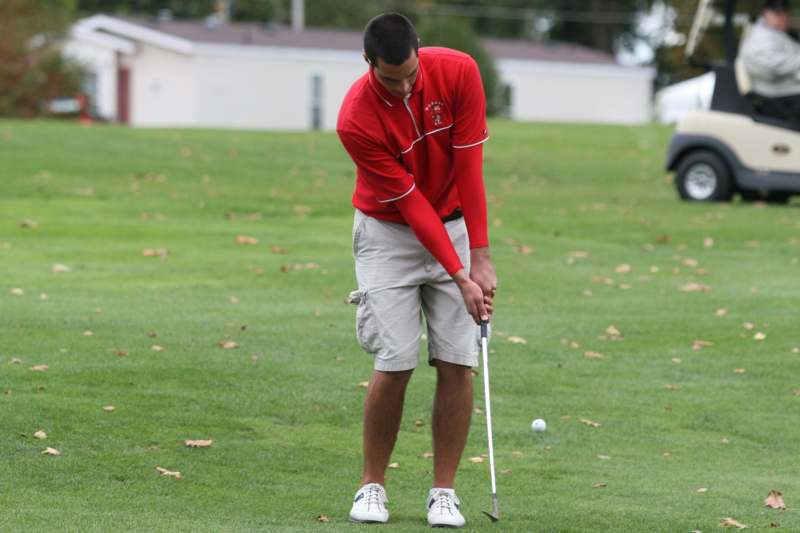 a man in a red shirt playing golf