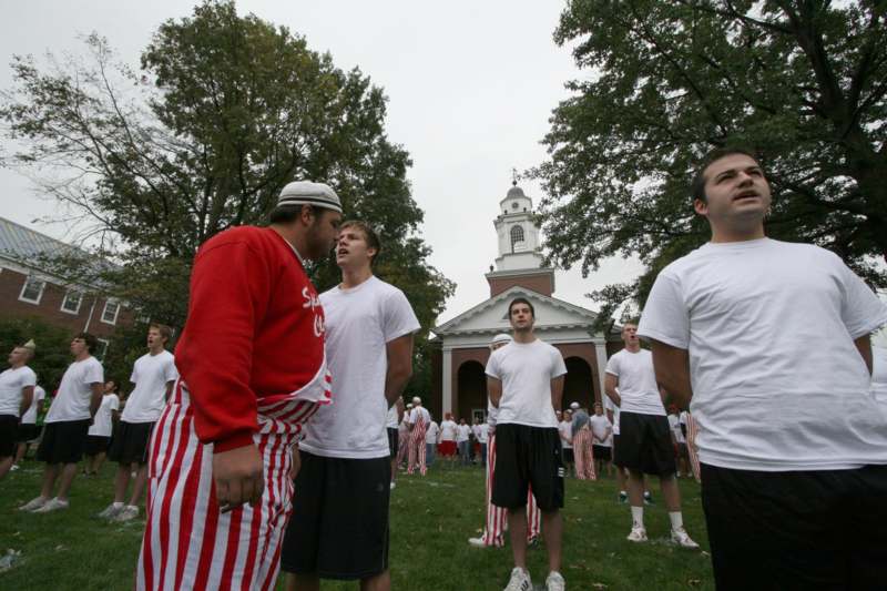 a group of men in white shirts and striped shorts