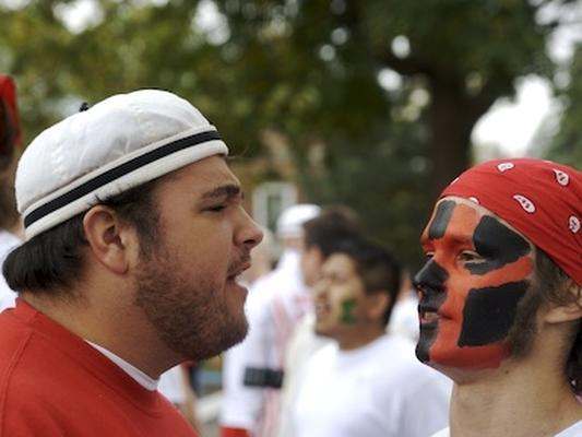 a man with face paint looking at another man