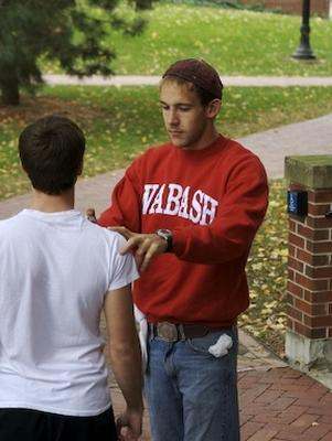 a man in a red shirt talking to a young man