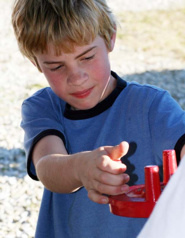 a boy pointing at a red object