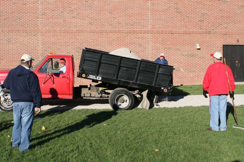 a truck with a dump truck in front of a brick wall