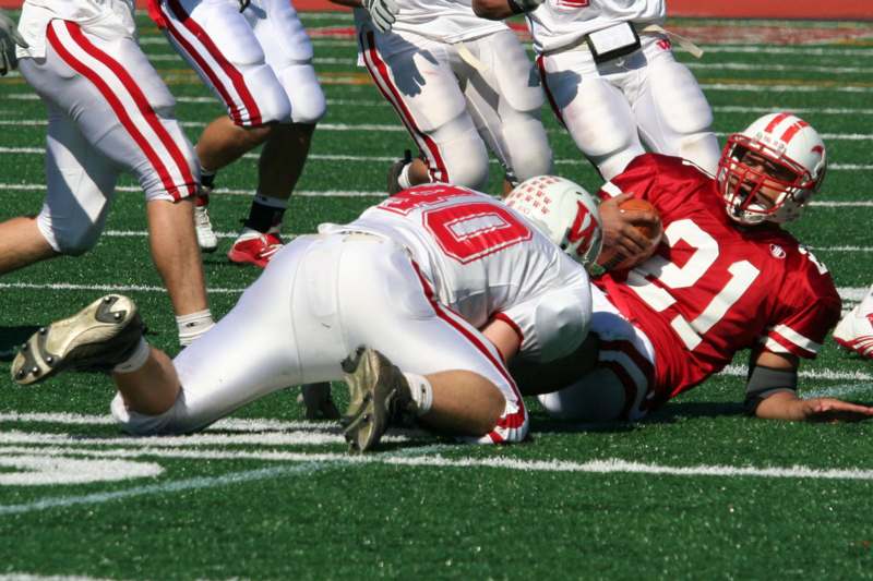 a football player falling down while another player is falling