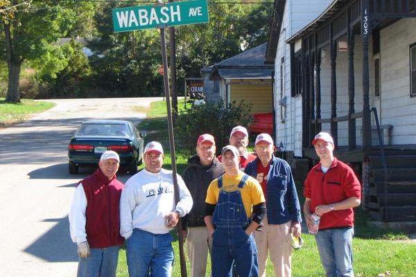 a group of men standing in front of a street sign