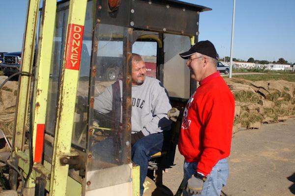 a man talking to another man in a tractor