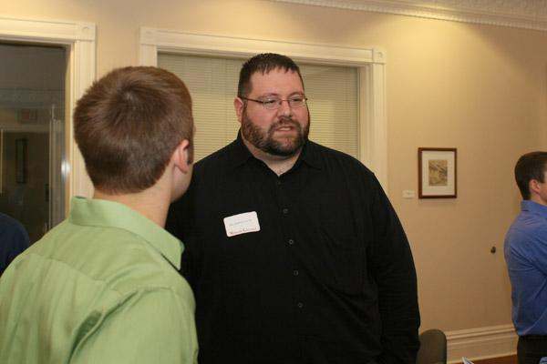a man in a black shirt talking to a boy