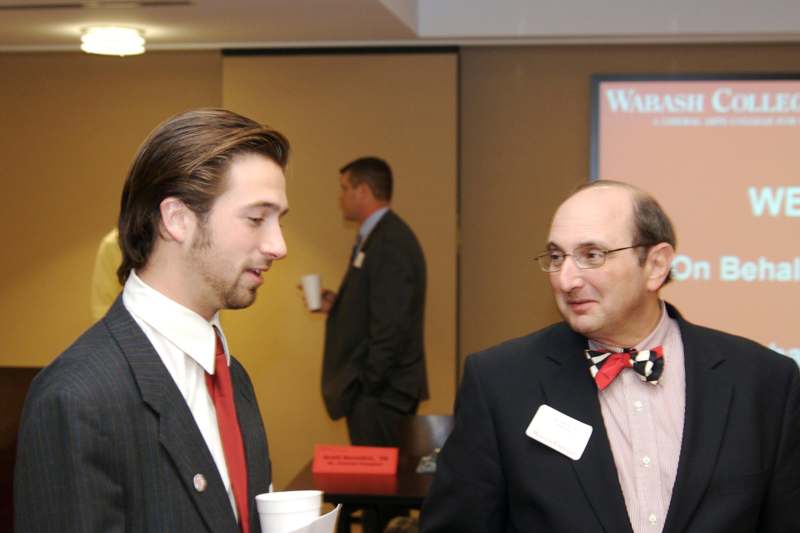 a man in suit talking to another man