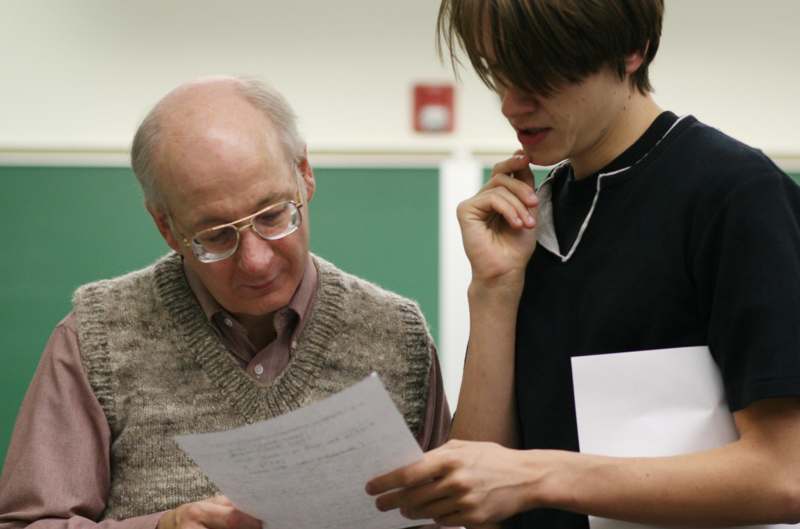 a man and a young man looking at a piece of paper