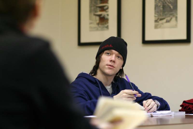 a man in a beanie sitting at a table