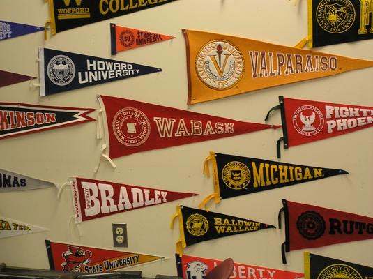 a group of college pennants on a wall