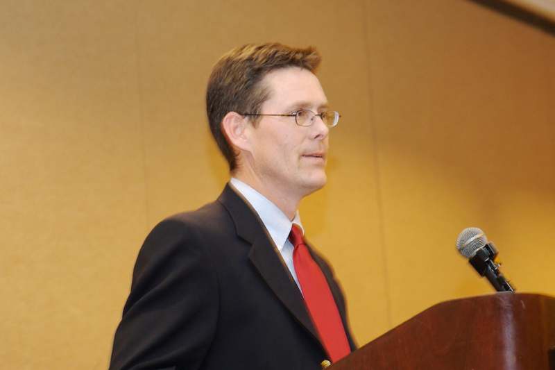 a man in a suit and tie standing at a podium