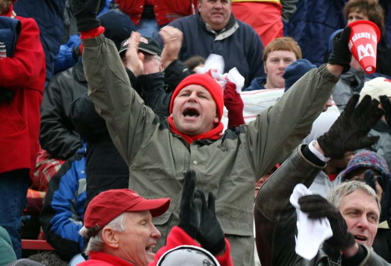 a man in a red hat with his mouth open and his hands up