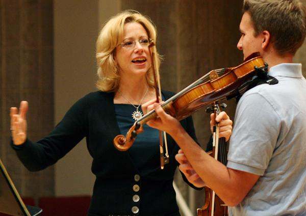 a woman playing a violin with a man