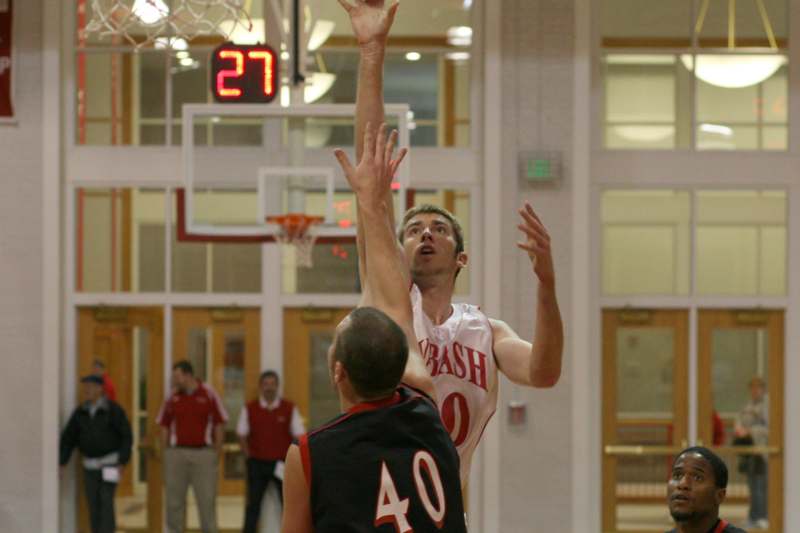 a man in a basketball uniform making a jump shot