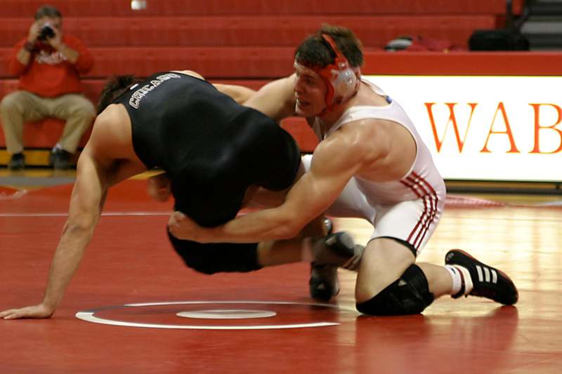 a man wrestling on a red mat