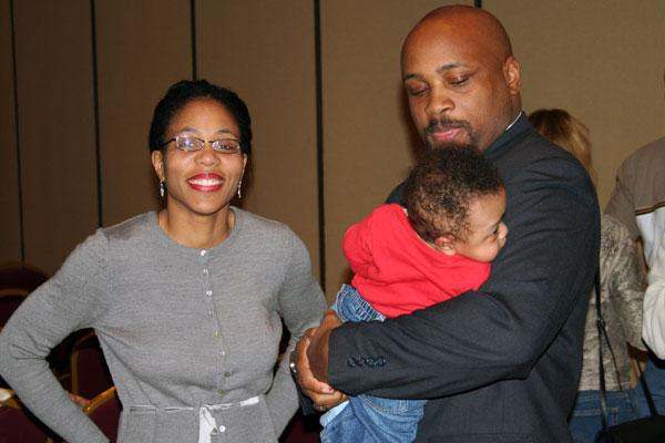 a man and woman holding a baby