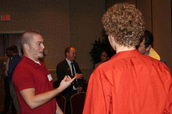 a man in a red shirt talking to a woman