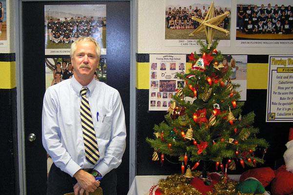 a man standing next to a christmas tree