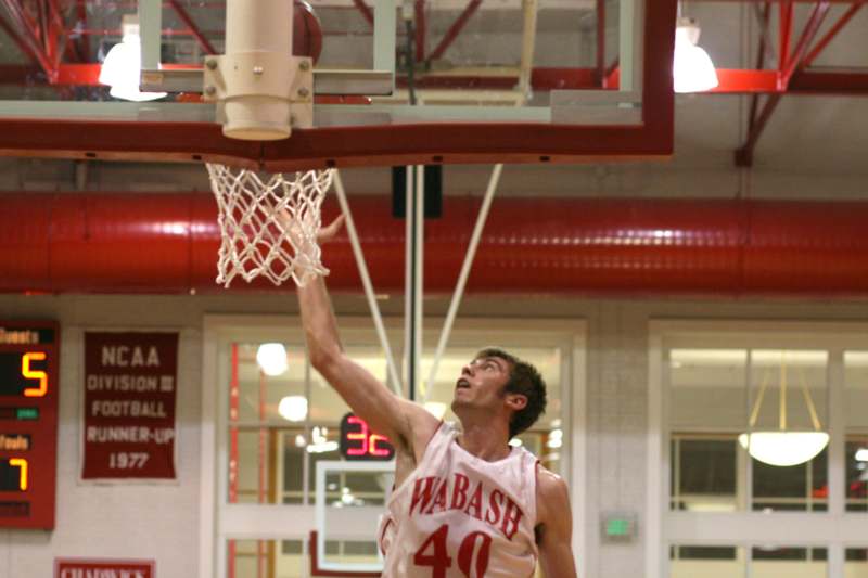 a man in a basketball jersey dunking a basketball