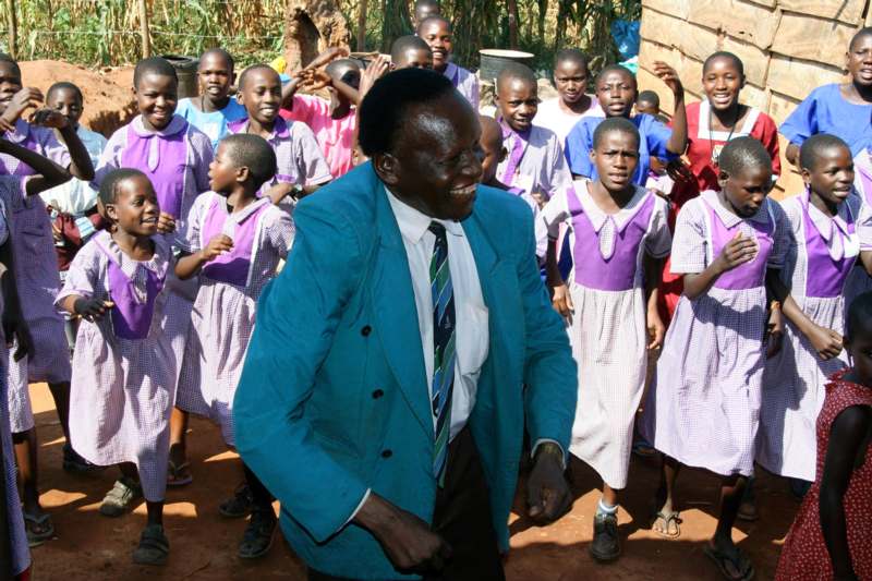 a man in a suit and tie with a group of children in the background
