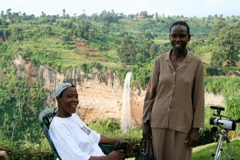 a woman standing next to a woman in a chair
