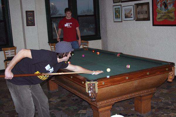a man playing pool with a stick