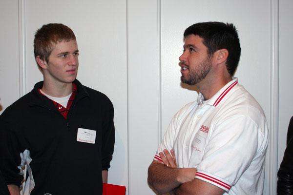 a man standing next to another man