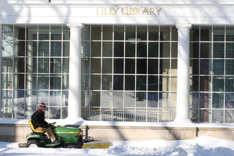 a man riding a lawnmower in front of a library