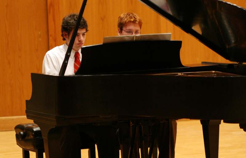 a couple of men playing piano