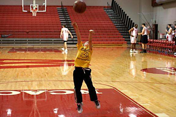 a boy jumping to shoot a basketball