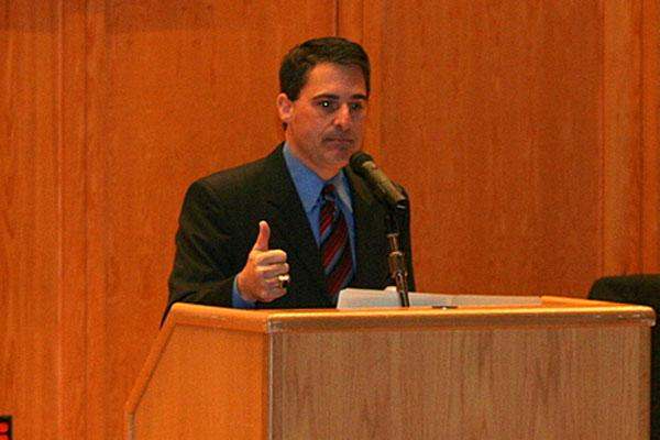 a man giving a thumbs up at a podium
