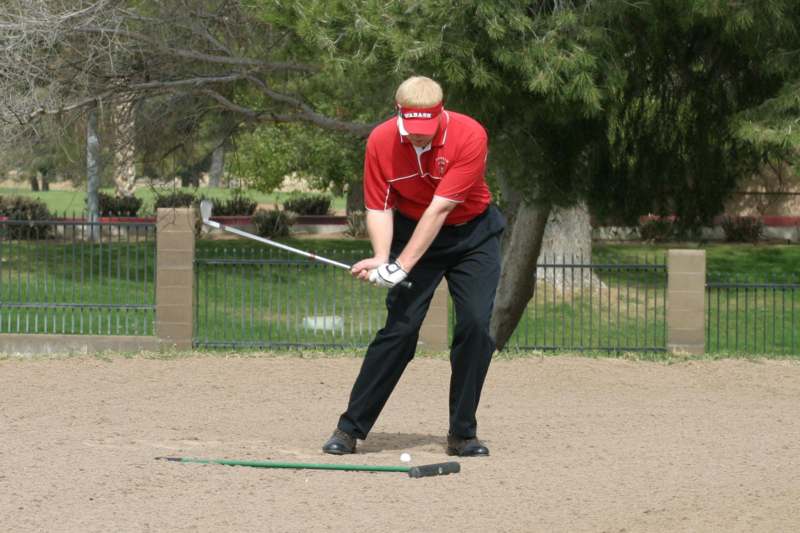 a man playing golf on a sand trap