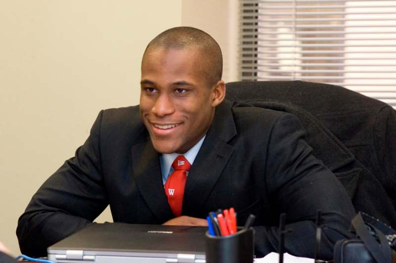 a man in a suit and tie sitting at a desk