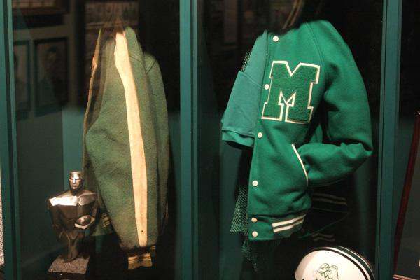 a green jacket with a letter m on it