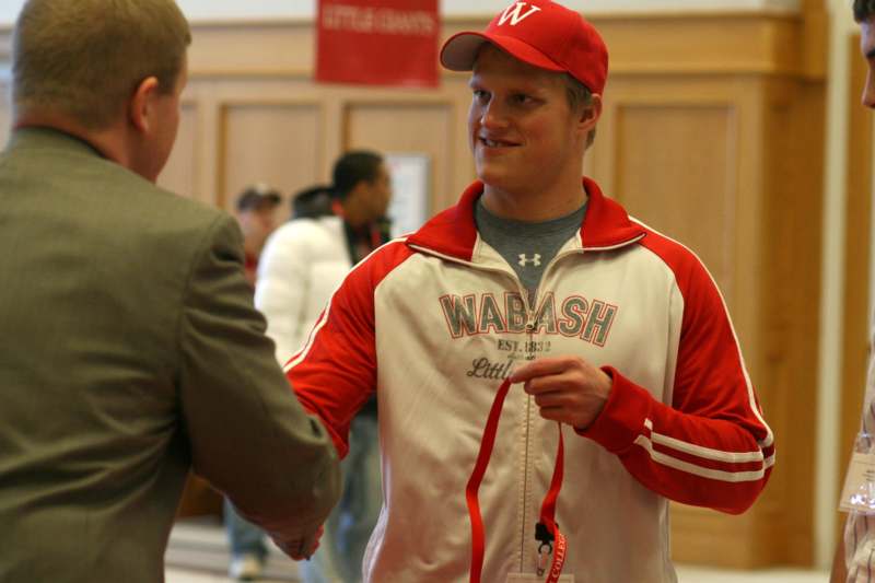 a man in a red cap shaking hands with another man