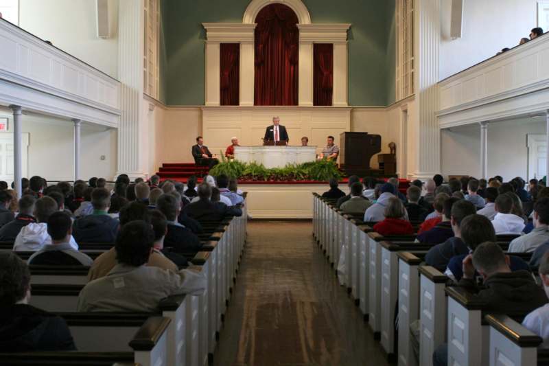 a man standing on a podium in front of a group of people seated in a church