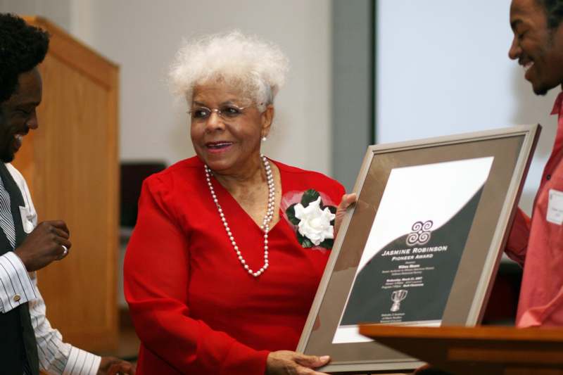 a woman holding a framed award