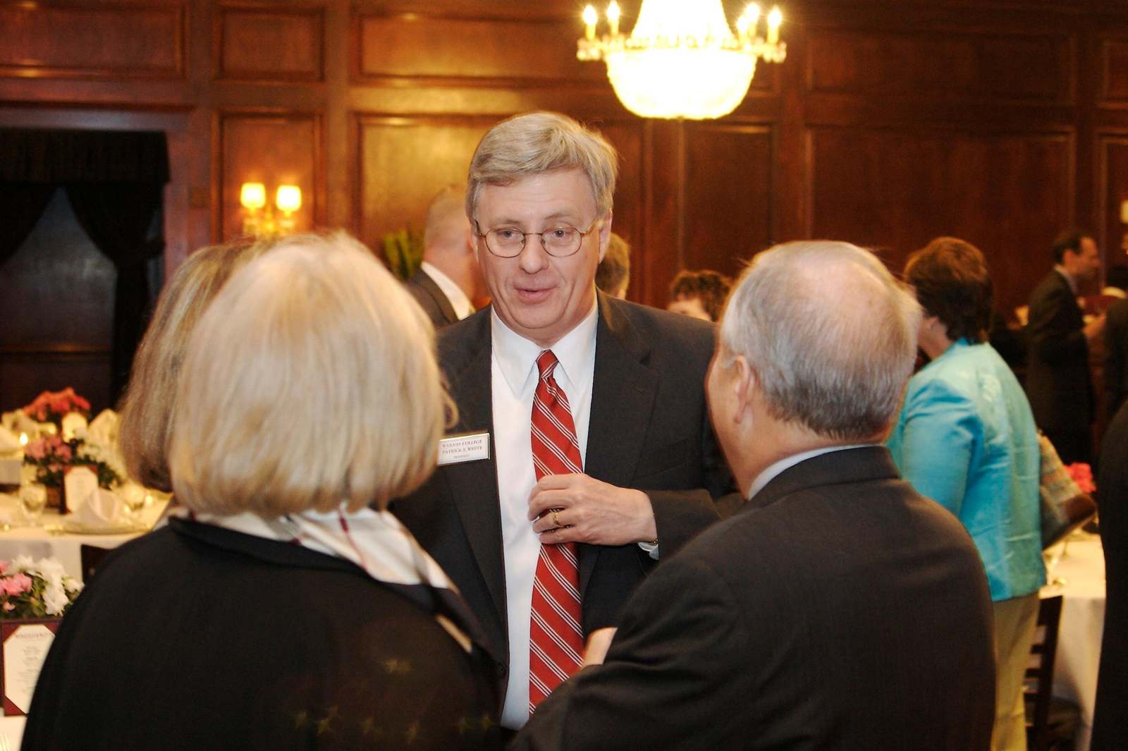 a man in a suit talking to a group of people